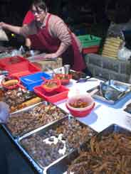Meat food booth at the night market with chicken feet in the foreground