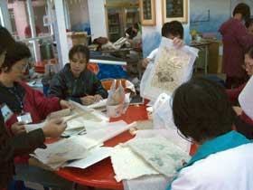 students taking off dried paper from fabric