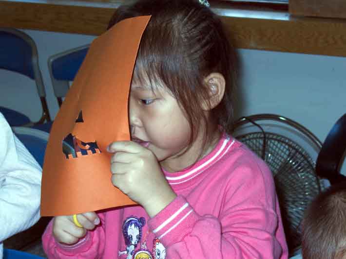 Little girl cutting teeth in pumkin mask