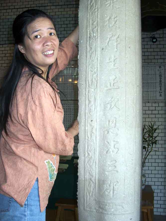 shu-fen taking down paper from temple column